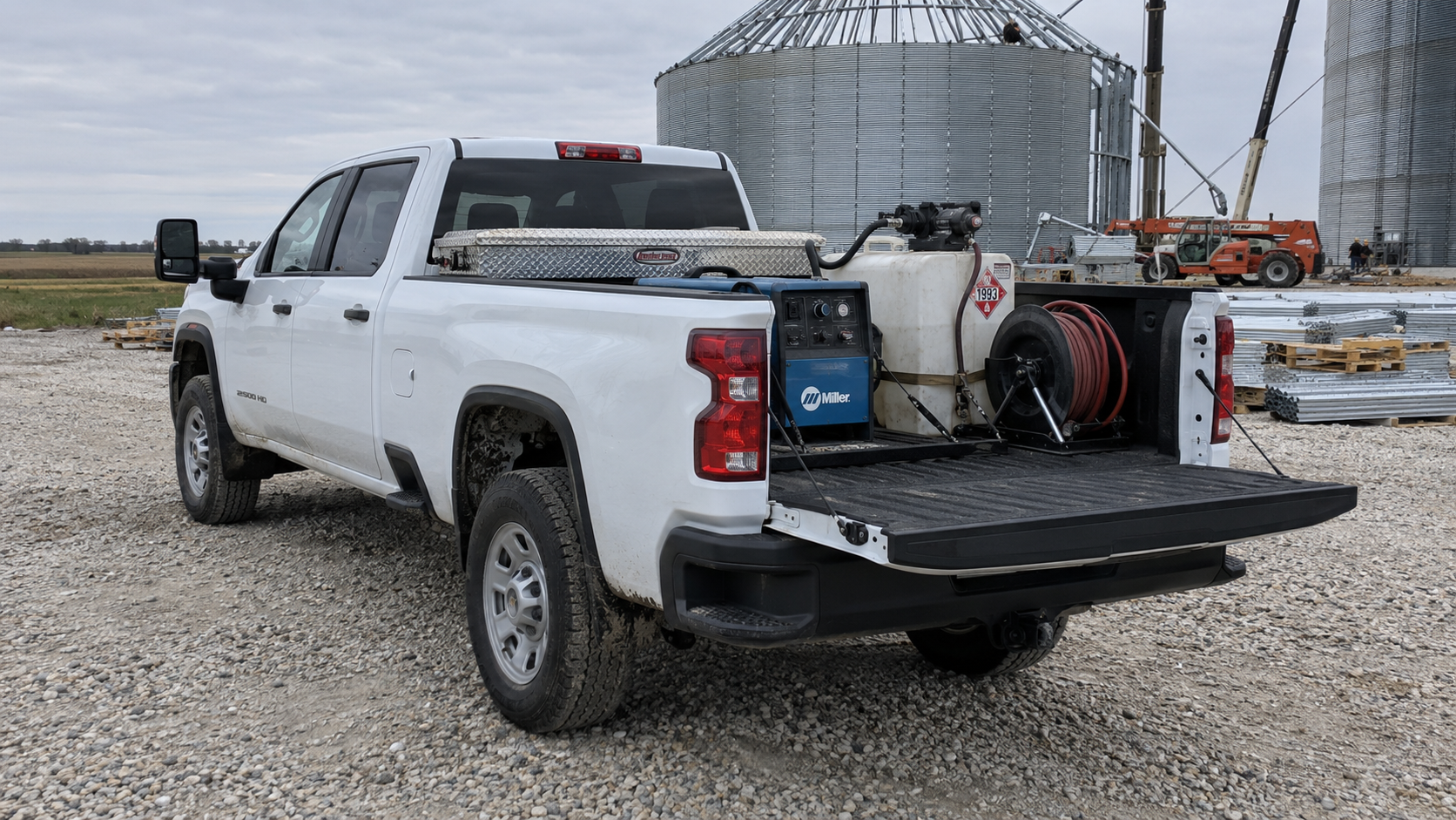 2026 GMC Sierra 2500 HD Pro work truck in Summit White with a welder in the bed on a jobsite near Mobridge, South Dakota